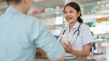 Medicine and health concept, Female pharmacist hold pill bottle and explain take medicine to client.