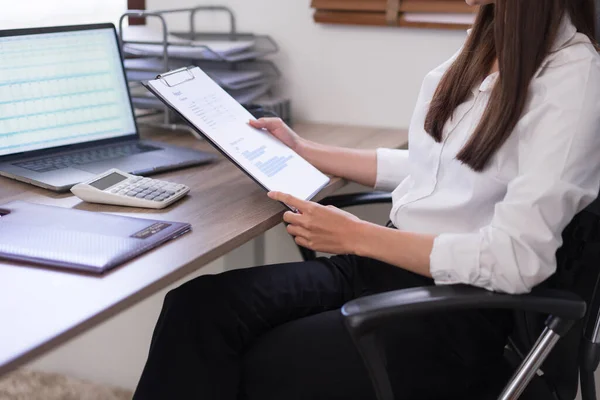 Business concept, Businesswoman holding clipboard and reading business document to analysis budget.