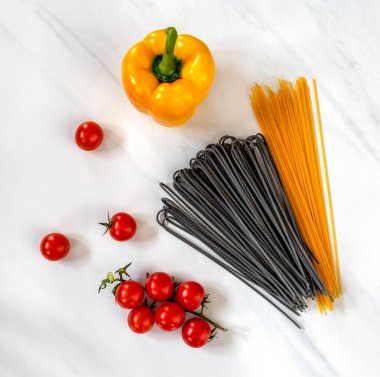 siyah ve karamelli makarna ve domatesler mermer tahtada