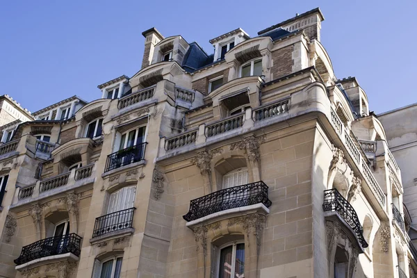 The upper floors of a residential building in Paris on blue sky