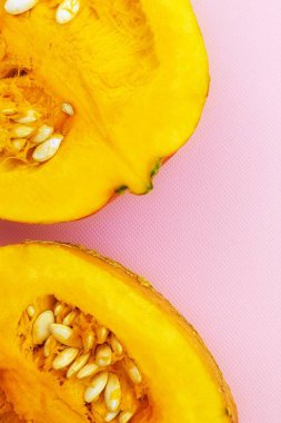 Bir balkabağının üst görüntüsü iki eşit parçaya bölünmüş, hamuru ve tohumları ile