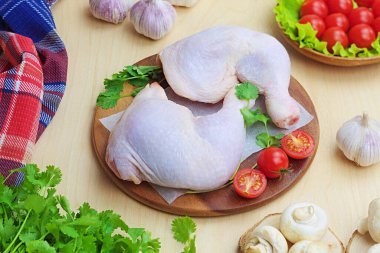 İki çiğ tavuk bacağı ahşap bir büfede yatıyor.