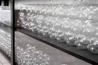 Boş plastik şişeler depo raflarında sıra sıra dizilmiş. Seçici odak