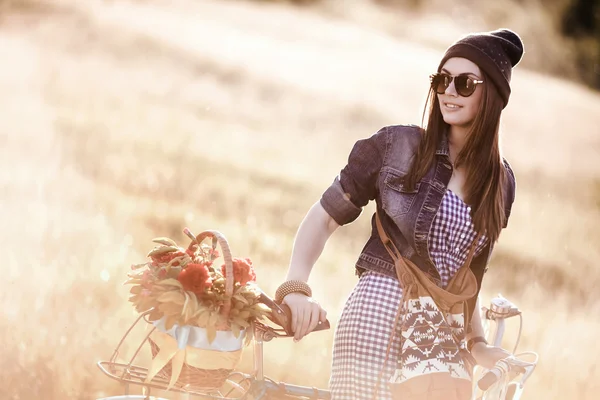 Young pretty brunette woman posing on the nature with bike in summer sunshine. Fashion portrait. — Stock Photo, Image