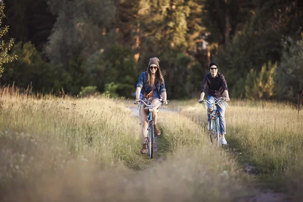 Two beautiful hipsters standing outdoor in summer with white vintage fixed gear bicycle — Stock Photo, Image