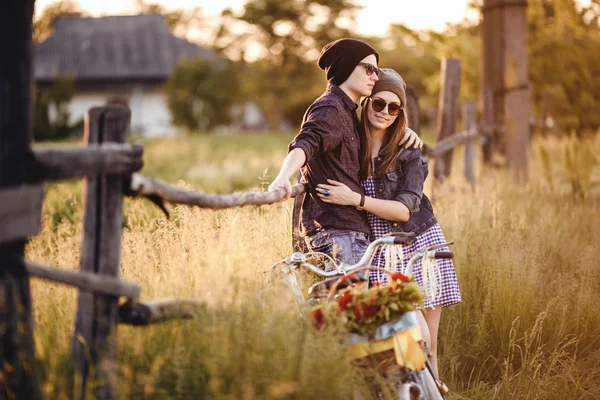 Dois hipsters lindos em pé ao ar livre no verão com bicicleta de engrenagem fixa vintage branca — Fotografia de Stock