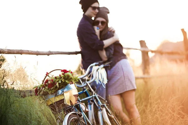 Two beautiful hipsters standing outdoor in summer with white vintage fixed gear bicycle — Stock Photo, Image