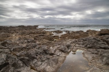 Vahşi deniz manzarası Galiçya İspanya 'daki dalgalar arasında kayaları gösteriyor.
