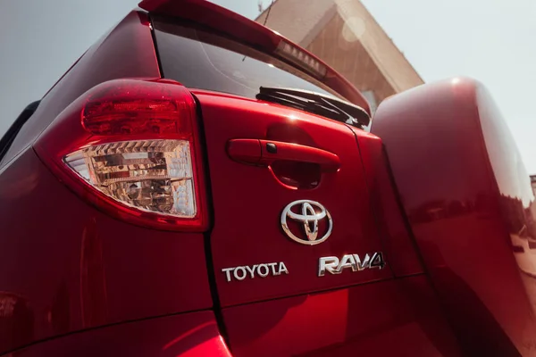 Modern kırmızı geçiş aracı 2008 Toyota Rav4 XA30 yaz otoparkında. Kırmızı arka farları, marka işareti ve tekerlek kapağı olan modern arabanın arka tarafı.