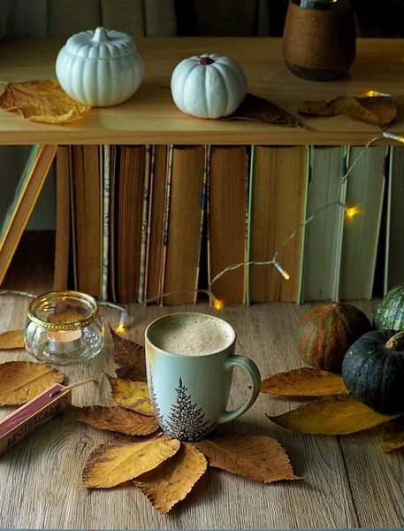 Coffee mug on the table decorated with lights and leaves