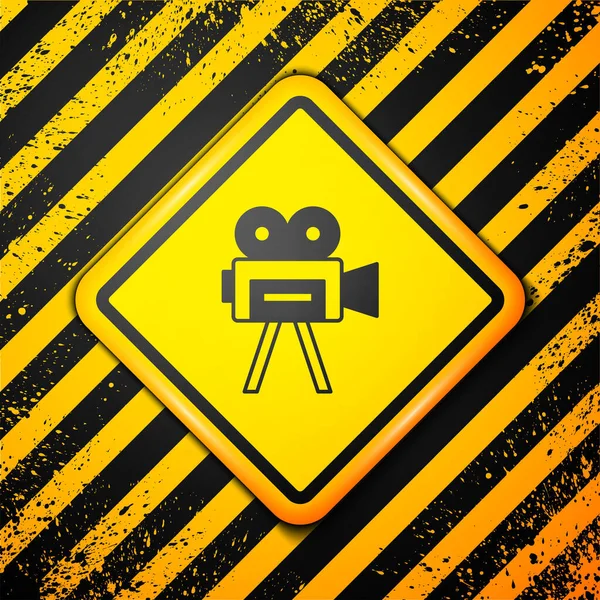 Icono de cámara de cine retro negro aislado sobre fondo amarillo. Videocámara. Signo de película. Proyector de cine. Señal de advertencia. Vector — Archivo Imágenes Vectoriales