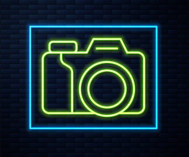 Parlayan neon hat kamera ikonu tuğla duvar arka planında izole edildi. Foto kamera. Dijital fotoğrafçılık. Vektör.