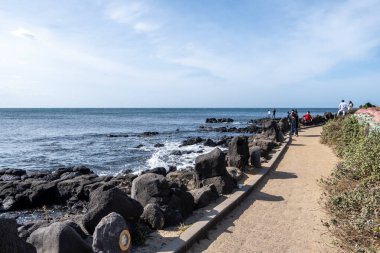 Aewol Handam sahil yolu çeşitli kafelerle çevrili. İzden sahil manzarası görünüyor. Jeju Adası, Güney Kore 'de 7 Kasım 2021' de çekildi.