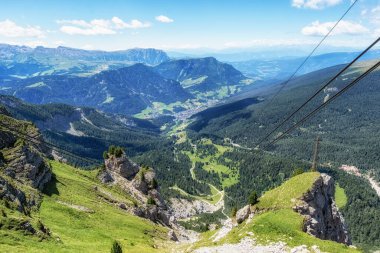Seceda teleferiğinden alınan Ortisei kasabasının manzarası. Val Gardena tepeleri boyunca dağlık evler. Dolomitler, İtalya