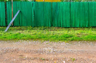 Arka plan rustik ahşap çit yeşil çim ve köy yolu ile