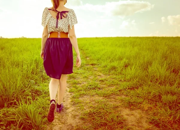 Fondo chica en un vestido y zapatillas de deporte caminando en un sendero en —  Fotos de Stock