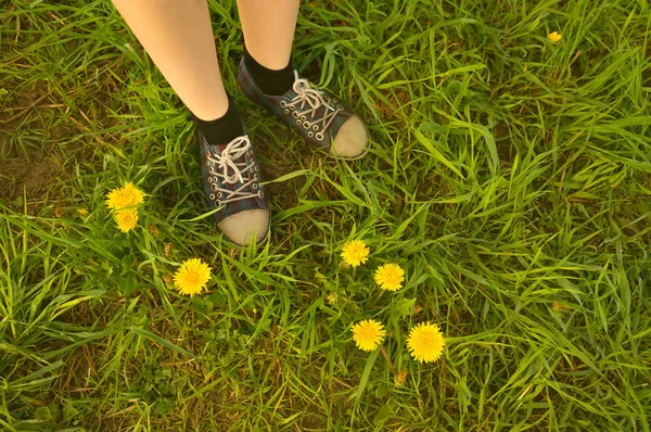 Sfondo piedi in scarpe da ginnastica di una ragazza nel campo — Foto Stock