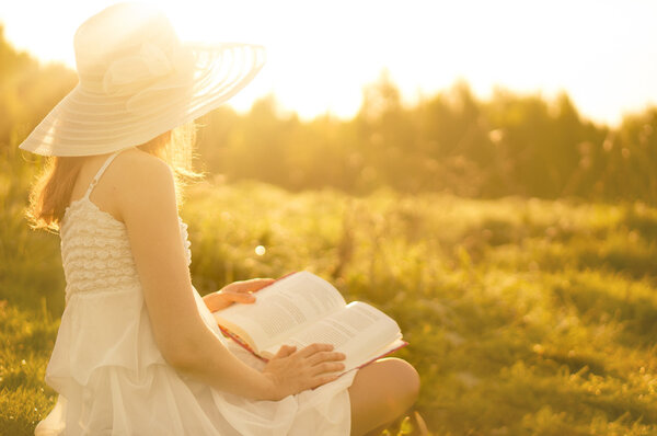 Girl in dress reading book. 