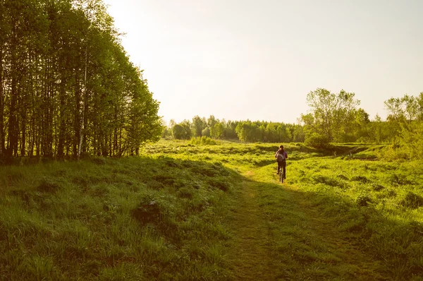 Landskap flicka på cykeltur på morgonen på en gångstig — Stockfoto