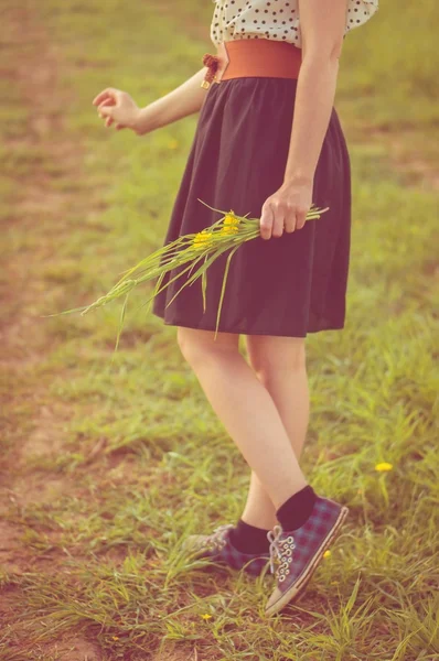 Hintergrund Mädchen steht in einem Feld in einem Kleid und Turnschuhen — Stockfoto