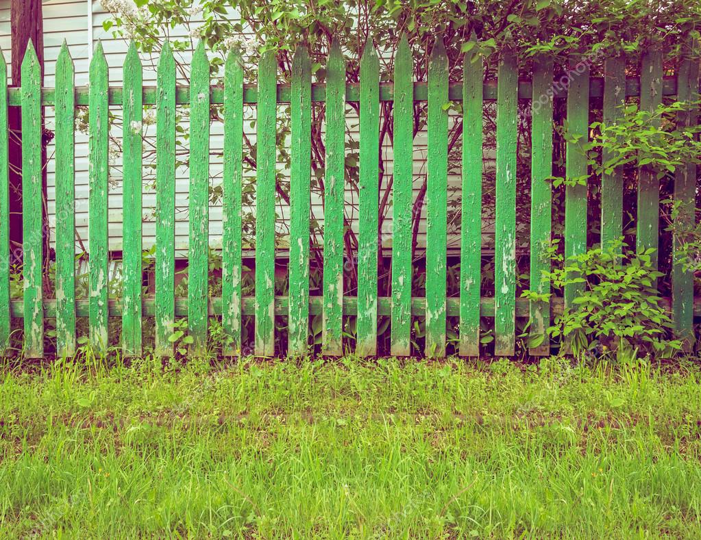 Background rustic wooden fence with green grass in front of it — Stock
