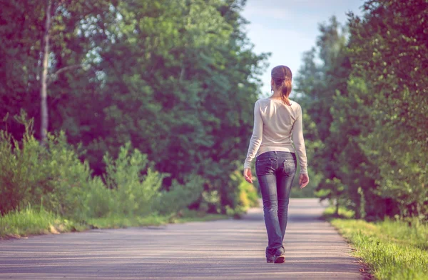 Background girl standing turned her back on urban asphalt road — Stock Photo, Image