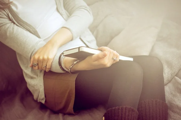 Graubraune Töne Hintergrund Mädchen sitzt auf einer Couch entspannen ind — Stockfoto