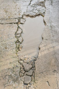 Beton yüzeyi, yol üzerinde yoksul inşaat nedeniyle yıkıldı.