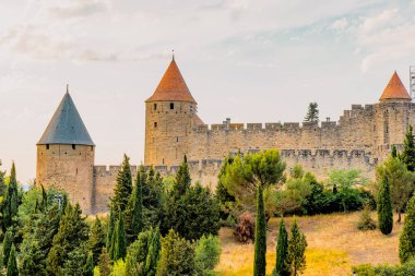 Carcassonne, Fransa - 02.07.2021: Batan güneşin ışığında Eski Carcassonne Kalesi. Fransız Kalesi
