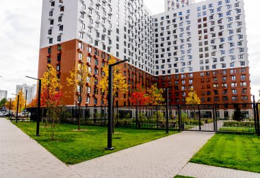Moskova, Rusya - 06.10.2021: Genç aileler için yeni modern yerleşim yerlerinin çok renkli güzel binaları. Bahçede oyun parkı. Parlak cepheli yerleşim bölgesi