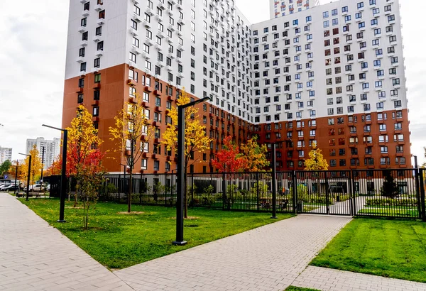 Moskova, Rusya - 06.10.2021: Genç aileler için yeni modern yerleşim yerlerinin çok renkli güzel binaları. Bahçede oyun parkı. Parlak cepheli yerleşim bölgesi