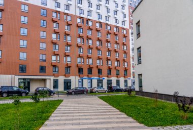 Moskova, Rusya - 06.10.2021: Genç aileler için yeni modern yerleşim yerlerinin çok renkli güzel binaları. Bahçede oyun parkı. Parlak cepheli yerleşim bölgesi. 
