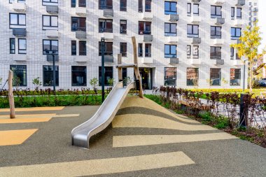 Moskova, Rusya - 04.10.2021: Genç aileler için yeni modern yerleşim yerlerinin çok renkli güzel binaları. Bahçede oyun parkı. Parlak cepheli yerleşim bölgesi. 