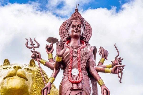 Mocná socha hinduistické bohyně Durga Maa se zlatým lvem v posvátném Ganga Talau. Kráterové jezero Grand Bassin, ostrov Mauricius. — Stock fotografie