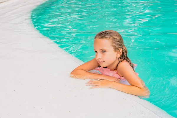 Gyönyörű kislány pózol a medencében.. Stock Kép