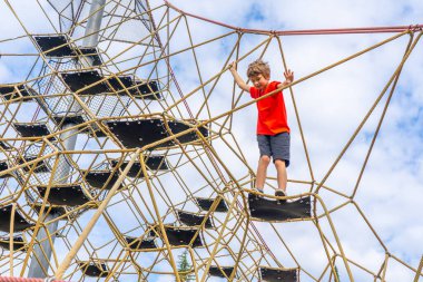  Bir çocuk oyun parkında çocukların tırmanma sahasına tırmanıyor. Yüksek kalite fotoğraf