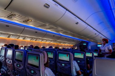 Nice, Fransa - 24.10.2021: Emirates Havayolları uçak kabini ve televizyon izleyen yolcular. Yüksek kalite fotoğraf