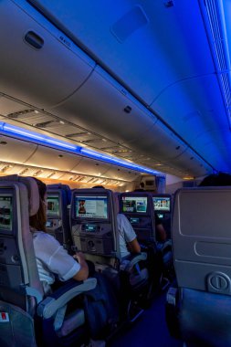 Nice, Fransa - 24.10.2021: Emirates Havayolları uçak kabini ve televizyon izleyen yolcular. Yüksek kalite fotoğraf