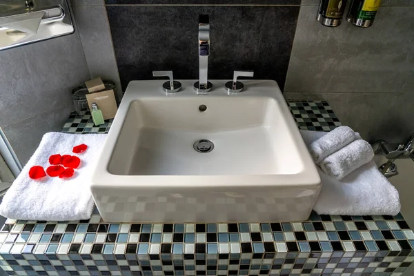 Paris, FRANCE - 11.11.2021 siyah beyaz taş dekorlu ve duşlu lüks banyo. Beyaz lavabo, tuvalet ve mobilya. Otel hijyen ürününün banyo tezgahına yakın çekimi. — Stok fotoğraf