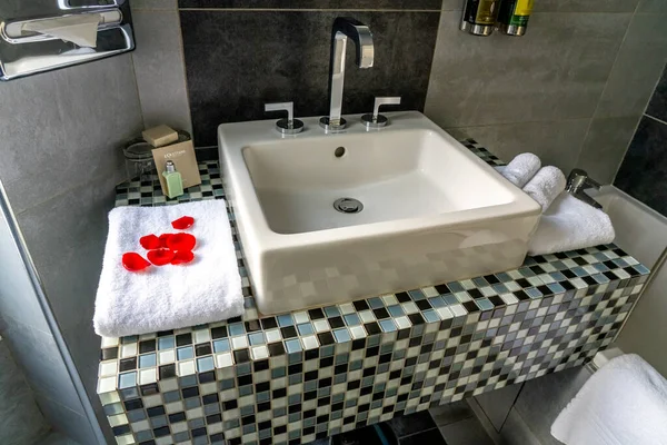 Paris, FRANCE - 11.11.2021 siyah beyaz taş dekorlu ve duşlu lüks banyo. Beyaz lavabo, tuvalet ve mobilya. Otel hijyen ürününün banyo tezgahına yakın çekimi. — Stok fotoğraf