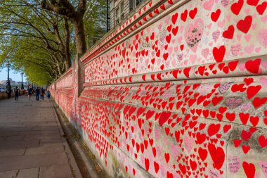 Westminster, Londra İngiltere - 20.04.2022: Covid kurbanlarının ölüm tarihleri ve isimleri ile kırmızı kalplerle boyanmış Ulusal COVID Anıt Duvarı.