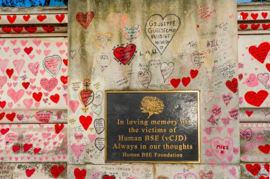 Westminster, Londra İngiltere - 20.04.2022: Covid kurbanlarının ölüm tarihleri ve isimleri ile kırmızı kalplerle boyanmış Ulusal COVID Anıt Duvarı.