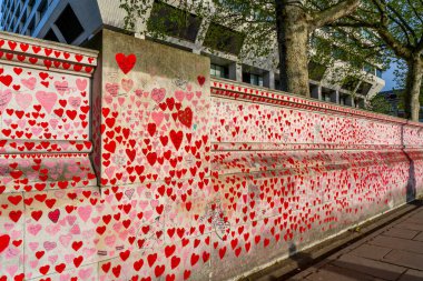 Westminster, Londra İngiltere - 20.04.2022: Covid kurbanlarının ölüm tarihleri ve isimleri ile kırmızı kalplerle boyanmış Ulusal COVID Anıt Duvarı.