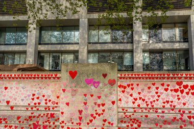 Westminster, Londra İngiltere - 20.04.2022: Covid kurbanlarının ölüm tarihleri ve isimleri ile kırmızı kalplerle boyanmış Ulusal COVID Anıt Duvarı. Yüksek kalite fotoğraf.