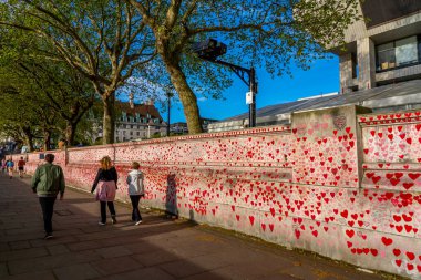 Westminster, Londra İngiltere - 20.04.2022: Covid kurbanlarının ölüm tarihleri ve isimleri ile kırmızı kalplerle boyanmış Ulusal COVID Anıt Duvarı.