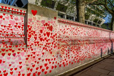 Westminster, Londra İngiltere - 20.04.2022: Covid kurbanlarının ölüm tarihleri ve isimleri ile kırmızı kalplerle boyanmış Ulusal COVID Anıt Duvarı.