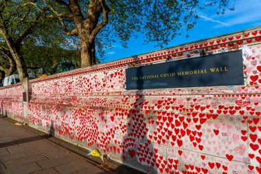 Westminster, London UK - 20.04.2022: The National COVID Memorial Wall painted with red hearts with the names, dates of death of Covid victims.