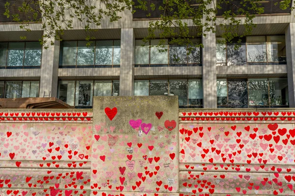 Westminster, Londra İngiltere - 20.04.2022: Covid kurbanlarının ölüm tarihleri ve isimleri ile kırmızı kalplerle boyanmış Ulusal COVID Anıt Duvarı. Yüksek kalite fotoğraf.