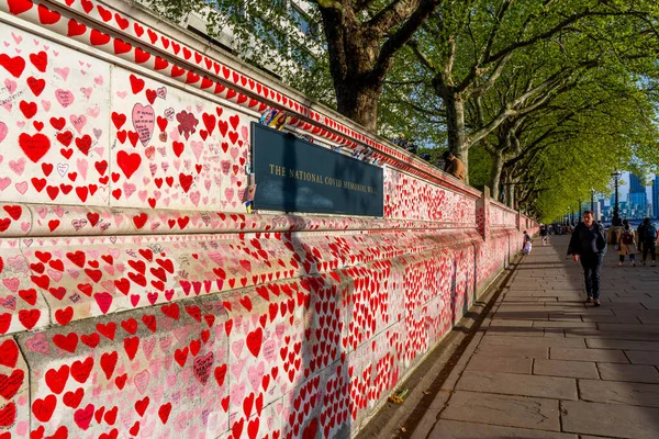 Westminster, Londra İngiltere - 20.04.2022: Covid kurbanlarının ölüm tarihleri ve isimleri ile kırmızı kalplerle boyanmış Ulusal COVID Anıt Duvarı.