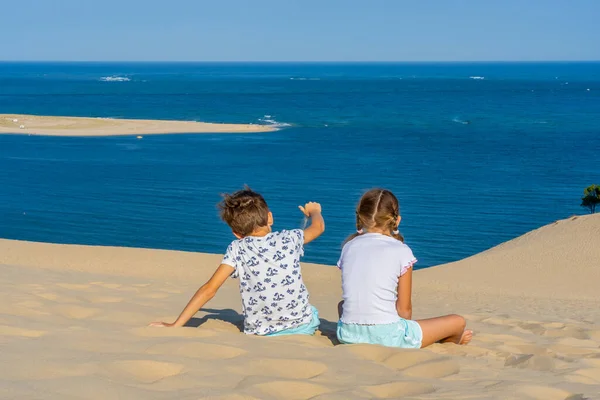 女の子と男の子の巨大な砂の砂丘 有名な観光地デューンピラに座っている フランスのピラト デューン 高品質の写真 — ストック写真